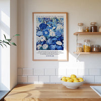 a kitchen scene with a framed poster of a blue floral pattern hanging on the wall above a wooden countertop with a bowl of lemons.