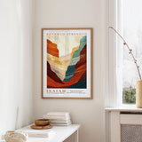 a framed poster of a mountain landscape with the text "RENEWED STRENGTH" and " Isaiah" below it, hanging on a wall in a room with a window and a small table with books and a bowl.