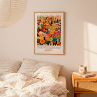 a bedroom scene with a bed, a nightstand, and a poster of a colorful floral design hanging on the wall above the bed.