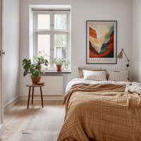 a cozy bedroom with a large bed, a wooden nightstand, and a window with a plant on the sill. The room has a warm, inviting atmosphere with a neutral color palette and natural elements.