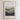 The image is a framed poster with a landscape scene depicting mountains and a person standing in the middle of the mountains. The poster has a minimalist design with a focus on the natural elements.