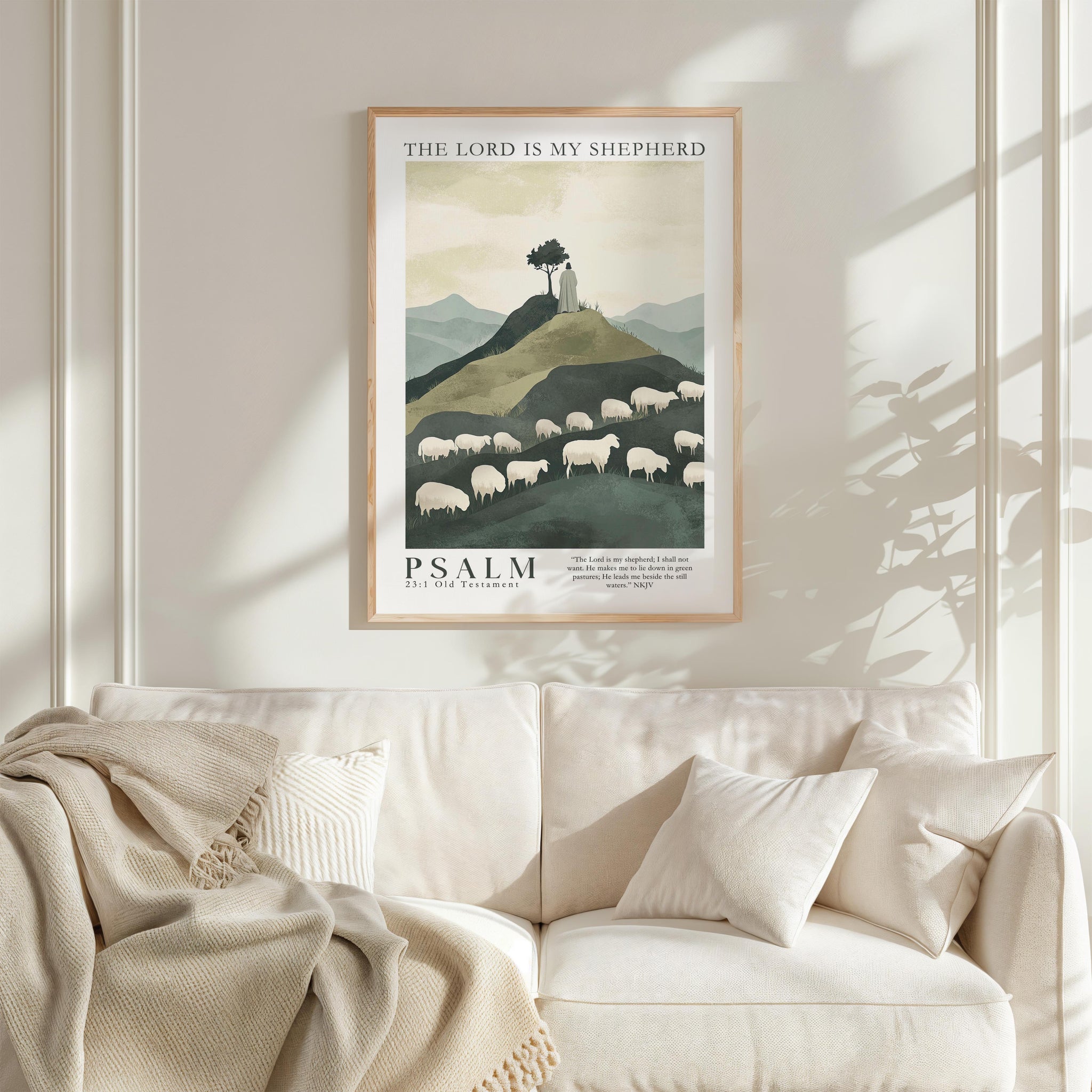 a framed poster of a pastoral scene with sheep grazing on a hill, hanging on a wall above a white couch with a blanket draped over it.