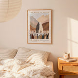 a bedroom setting with a framed poster of the biblical story of Exodus hanging on the wall above a bed with striped bedding.