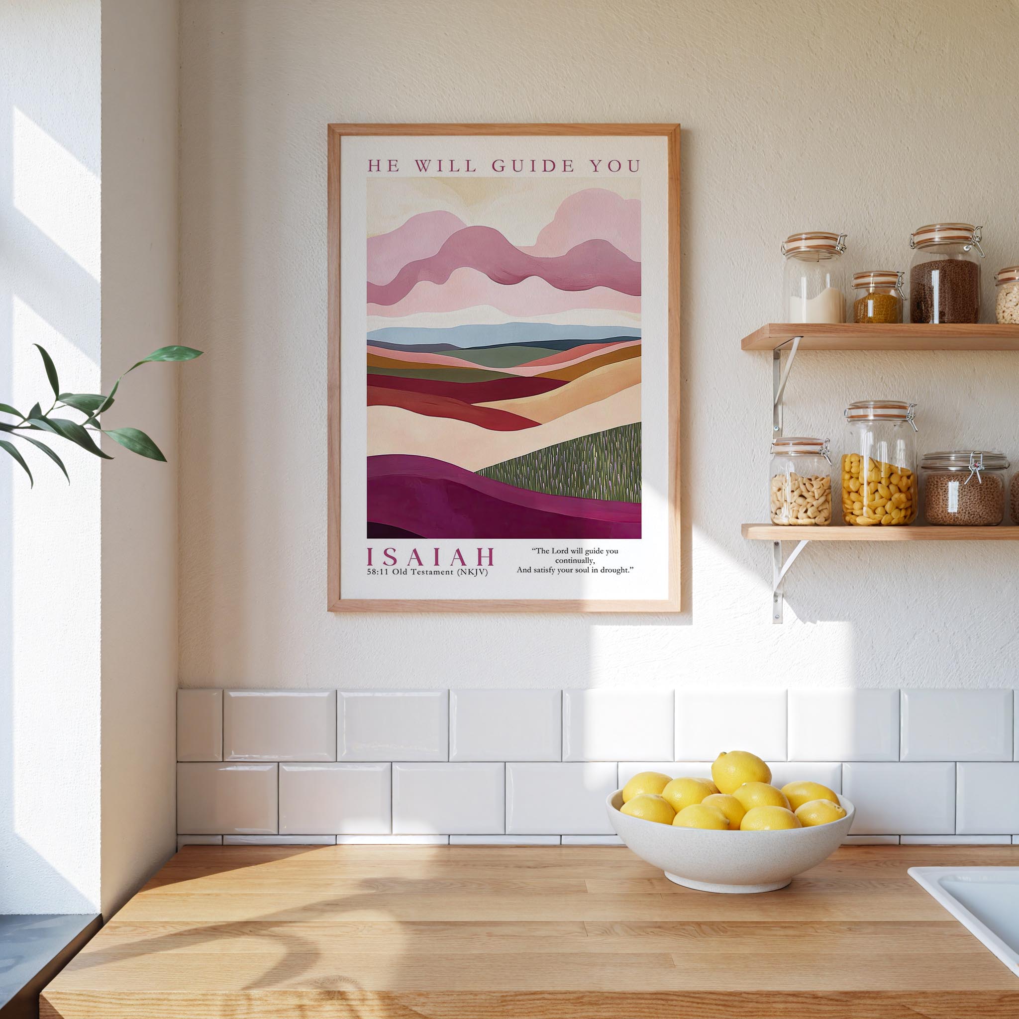 A framed poster of a landscape with mountains and hills hangs on a wall above a wooden countertop with a bowl of lemons.