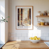 a kitchen counter with a bowl of lemons, a framed poster of a person, and a shelf with jars and containers.