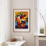 a framed poster of a vibrant fruit arrangement hanging on a wall in a room.