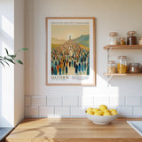 A framed poster of a large crowd of people is hanging on a wall above a wooden countertop with a bowl of lemons.
