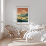 a bedroom with a bed, a woven chair, and a framed poster on the wall.