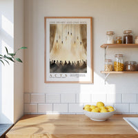 a kitchen scene with a framed poster of a group of people hanging on the wall above a wooden counter with a bowl of lemons.