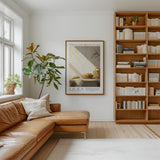 a cozy living room with a large bookshelf filled with books, a comfortable leather sofa, and a framed poster of a loaf of bread on the wall.