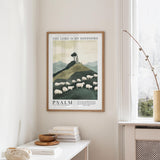 a framed poster of a pastoral scene with a mountain and sheep, hanging on a wall in a room with a window and a small table with books and a bowl.