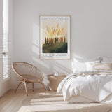 a serene bedroom scene with a bed, a woven chair, and a framed poster on the wall.