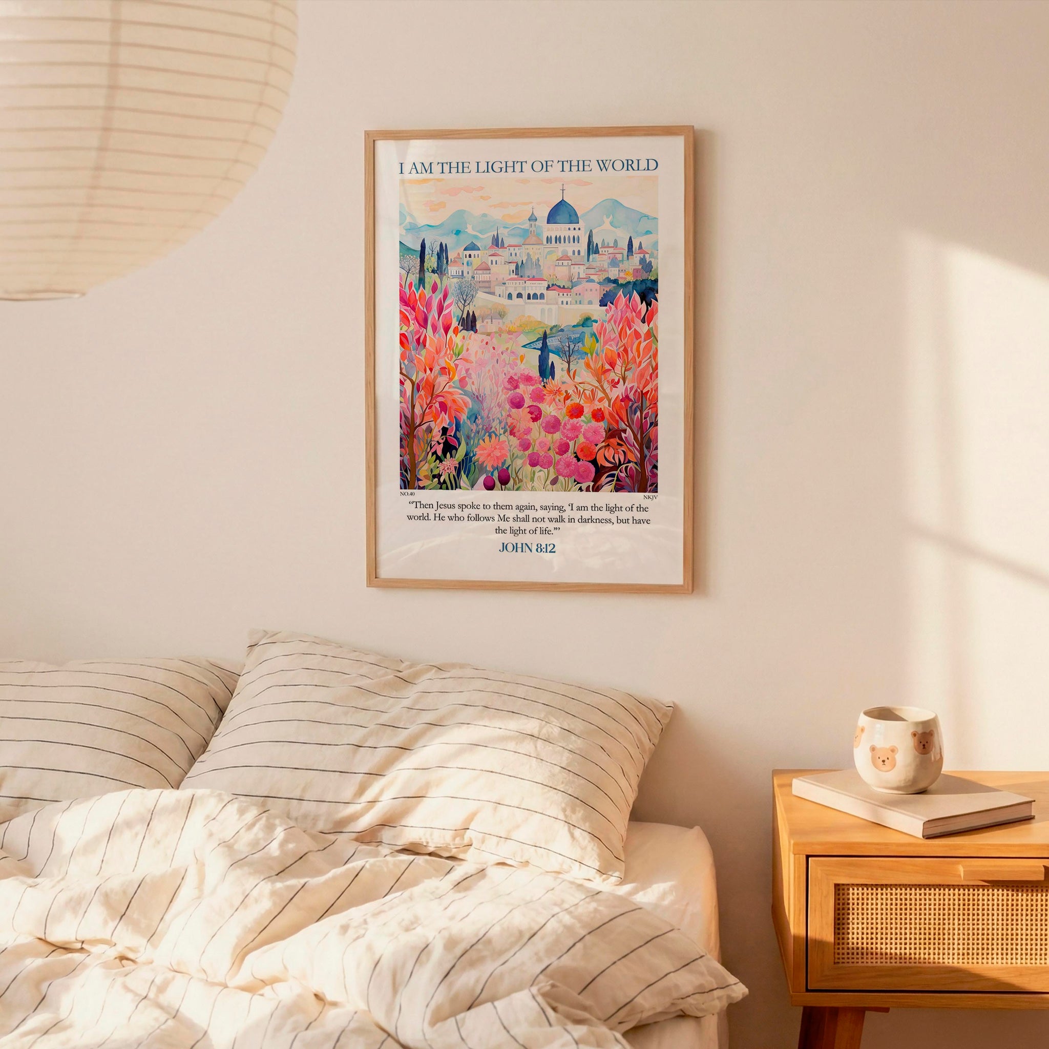 a bedroom scene with a framed poster of a colorful garden hanging on the wall above a bed with striped bedding.