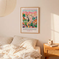 a bedroom setting with a framed poster of a desert landscape hanging on the wall above a bed with striped bedding.