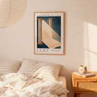 a bedroom scene with a framed poster of a book titled "The Book of Life" hanging on the wall above a bed with striped bedding.