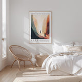 a serene bedroom scene with a bed, a woven chair, and a framed poster on the wall.