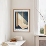 a framed poster of a staircase leading up to a book titled "The Book of Life" hanging on a wall in a room with a white table and a vase of flowers.
