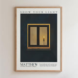 The image is a framed poster with a black background and a white border. The poster features a single candle in a window frame, with a quote from the New Testament about the light of the world.