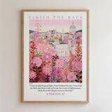 The image is a framed poster with a cityscape and pink flowers as the main elements. The poster features a quote from the Bible, specifically 2 Timothy 4:7, which reads, "I have fought the good fight. I have finished the race. I have kept the faith, and there is laid up for me the crown ofrighteousness, which the Lord will give to one on that Day."