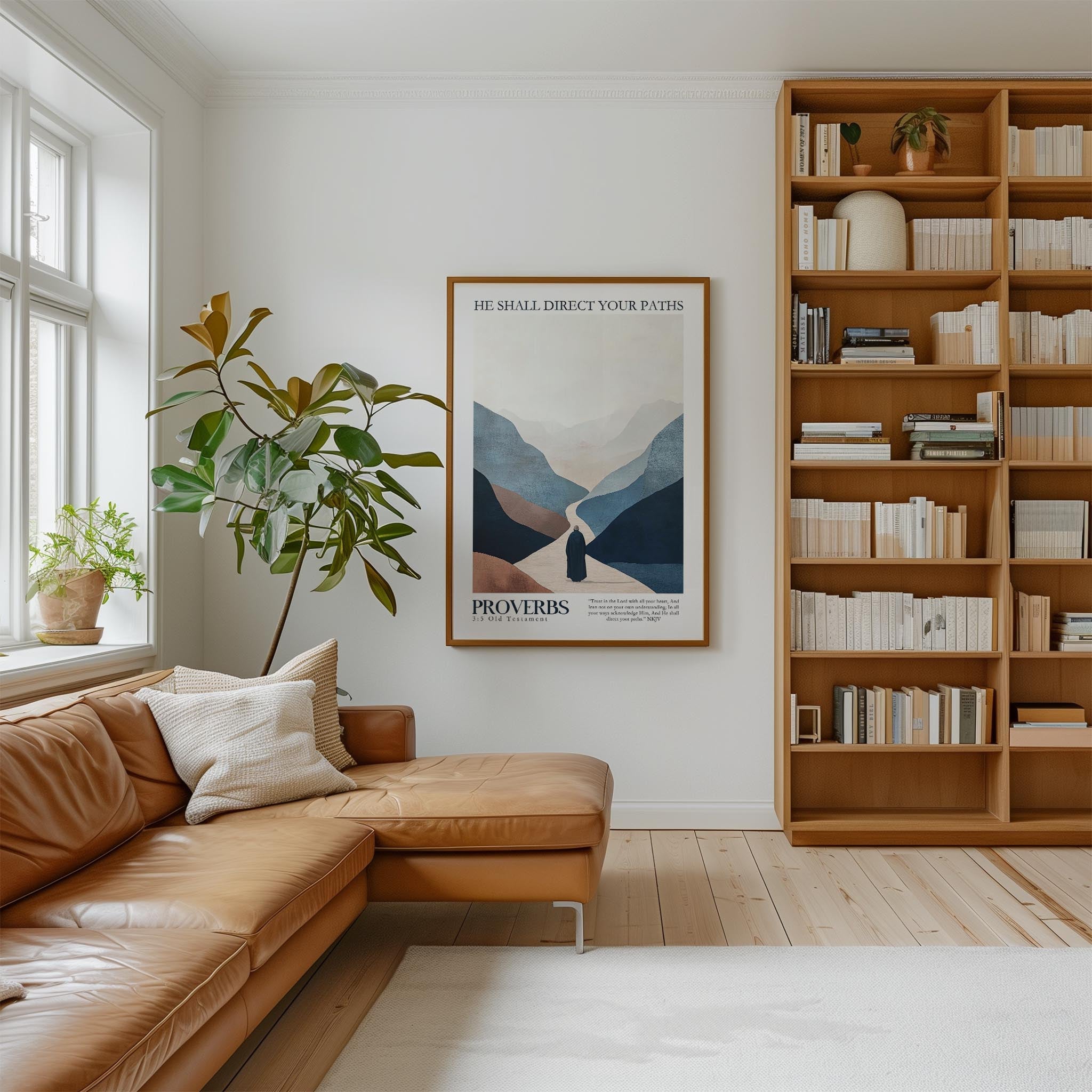 a cozy living room with a large bookshelf filled with books, a comfortable leather sofa, and a framed poster of a mountain landscape.