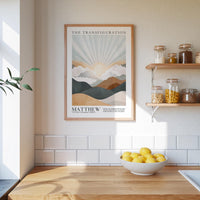 a kitchen scene with a framed poster of a mountain landscape hanging on the wall above a wooden countertop with a bowl of lemons.