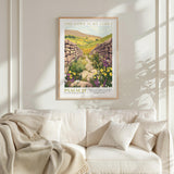 a framed poster of a stone path leading through a field of flowers, with the text "THE LORD IS MY LIGHT" and "PSALM 27" below it. The poster is hanging on a white wall above a white couch, which has a blanket draped over it.
