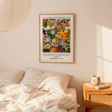 a bedroom scene with a framed poster of a colorful floral design hanging on the wall above a bed with striped pillows.