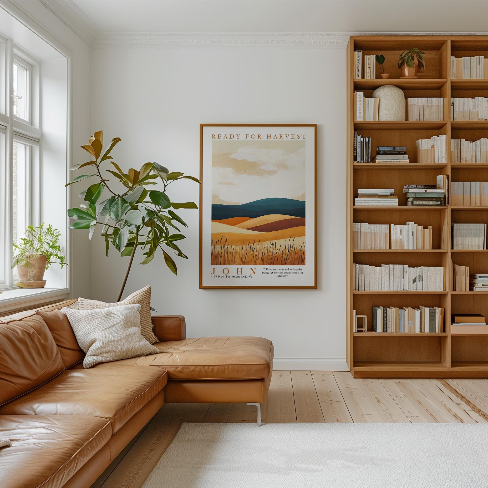 a cozy living room with a large bookshelf filled with books, a comfortable leather sofa, and a framed poster of a field with a tree.