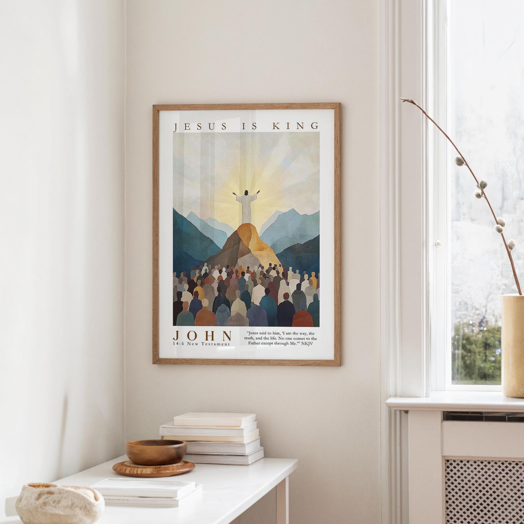 A framed poster of Jesus Christ is hanging on a wall, with a window and a small table with books and a bowl on it below.