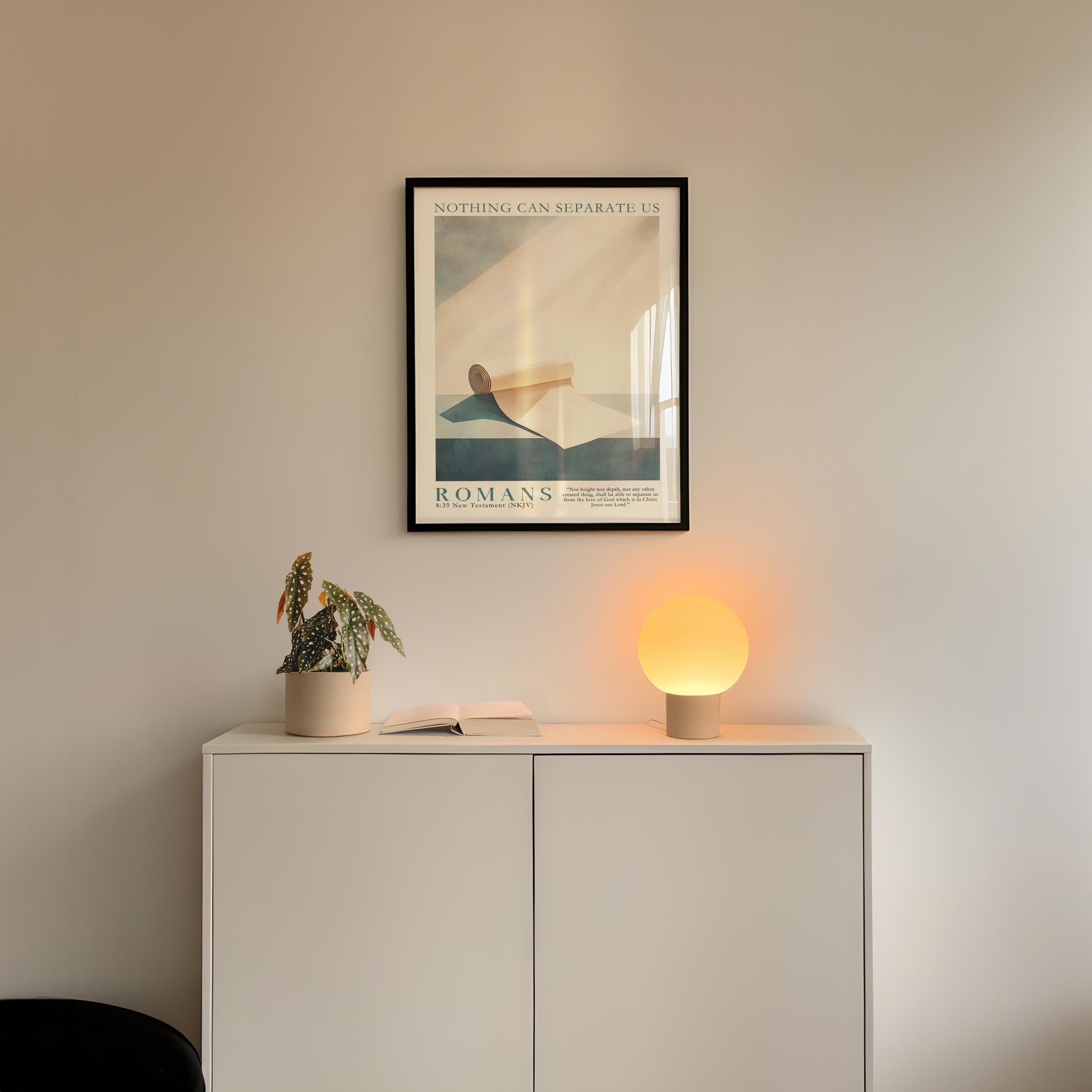 a minimalist interior design with a framed poster of a landscape, a potted plant, and a small lamp on a white cabinet.