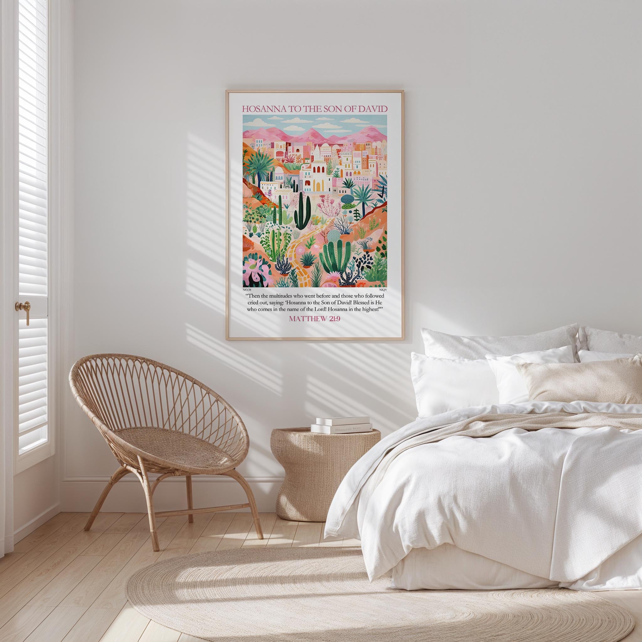 A bedroom with a bed, a woven chair, and a framed poster of a desert landscape with mountains in the background.