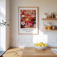 A framed poster of a vibrant floral arrangement hangs on a kitchen wall, accompanied by a bowl of lemons and a shelf with various jars and containers.