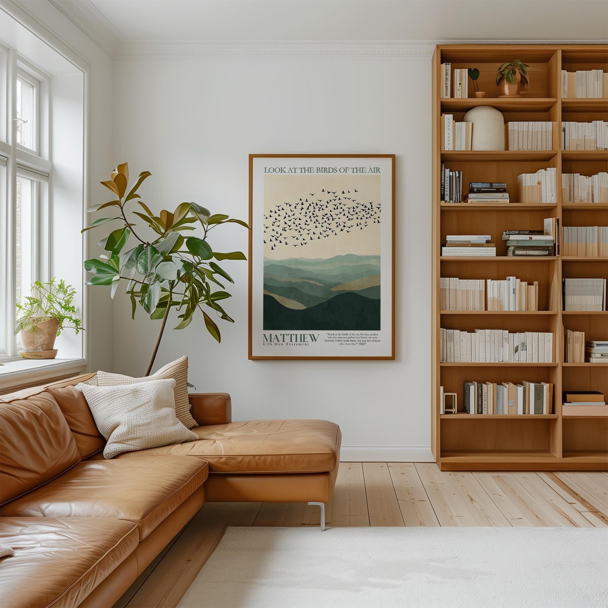 a cozy living room with a large bookshelf filled with books, a comfortable leather couch, and a framed poster of birds in flight on the wall.