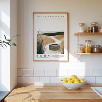 a kitchen scene with a framed poster of a well and a bowl of lemons on a wooden countertop.