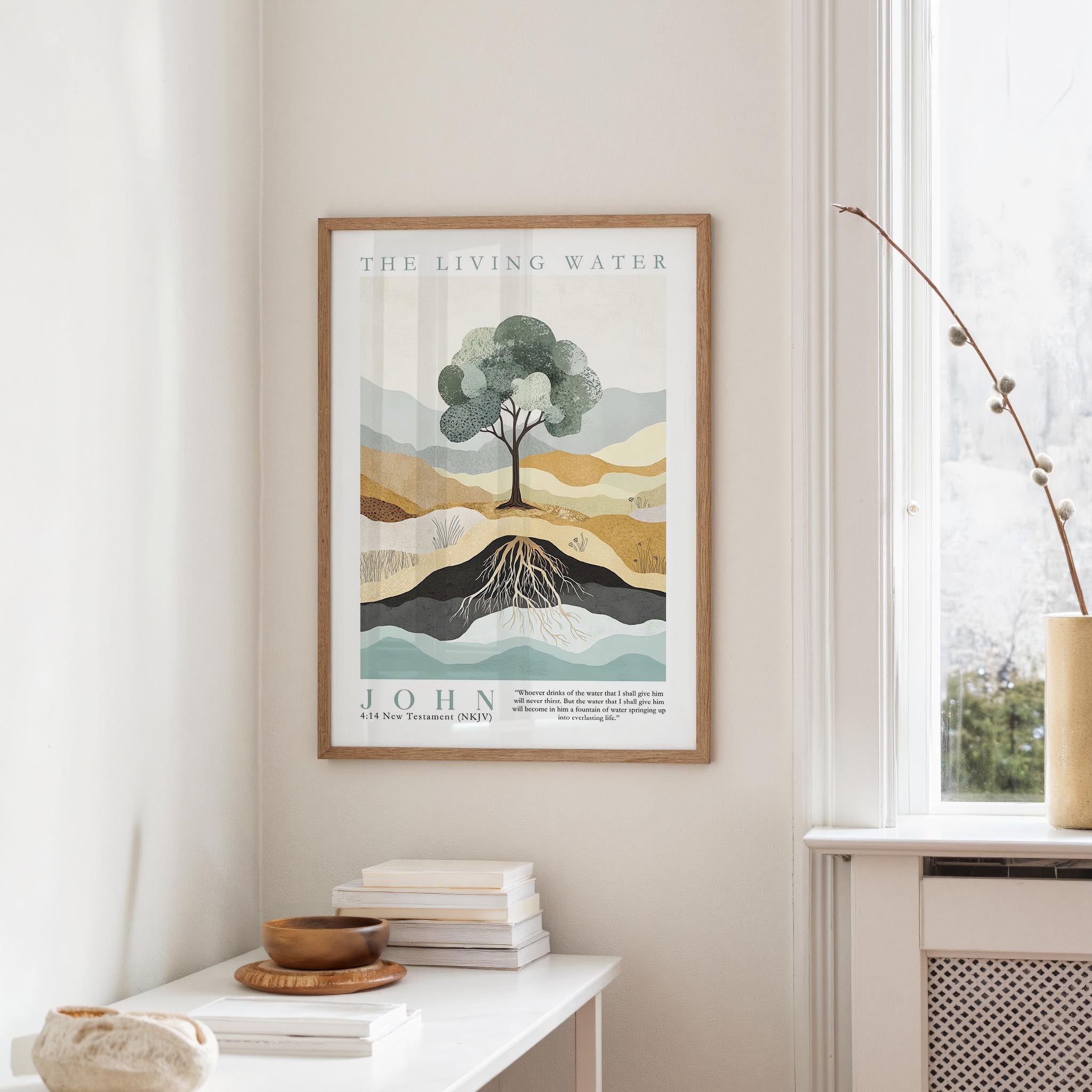 a framed poster of a tree with roots, hanging on a wall in a room with a window and a small table with books and a bowl on it.