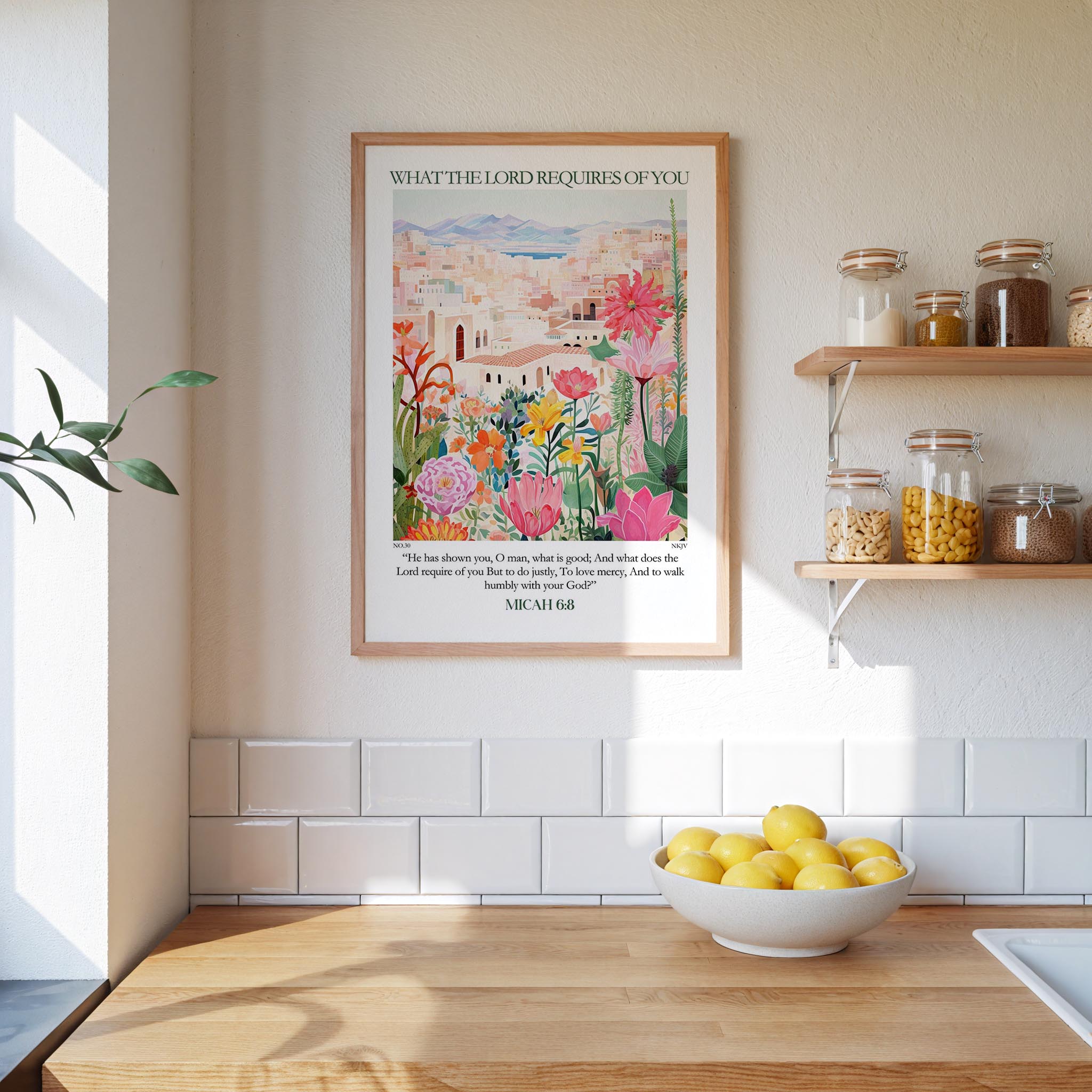 a kitchen scene with a framed poster of a colorful garden hanging on the wall above a wooden countertop with a bowl of lemons.
