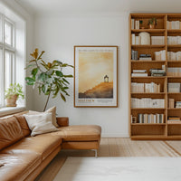 a cozy living room with a large bookshelf filled with books, a comfortable leather couch, and a framed poster of a lighthouse on the wall.