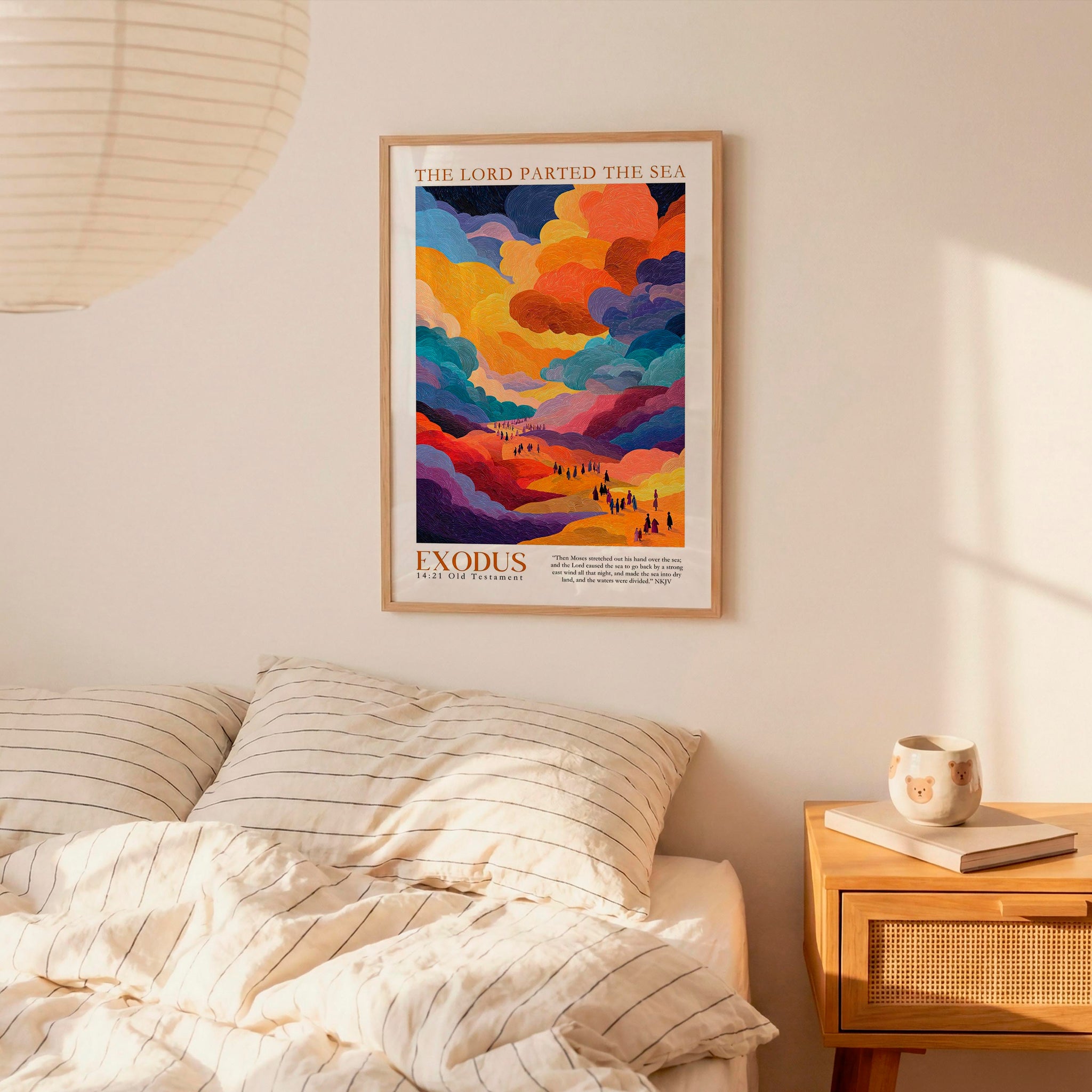a bedroom scene with a framed poster of a colorful landscape hanging on the wall above a bed with striped pillows.