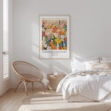 a serene bedroom scene with a bed, a woven chair, and a framed poster of a colorful floral design on the wall.