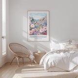a bedroom with a bed, a wicker chair, and a framed poster of a colorful floral landscape hanging on the wall.