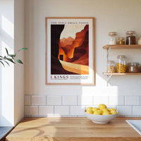 a kitchen counter with a bowl of lemons, a framed poster of a desert landscape, and a shelf with jars and other kitchen items.