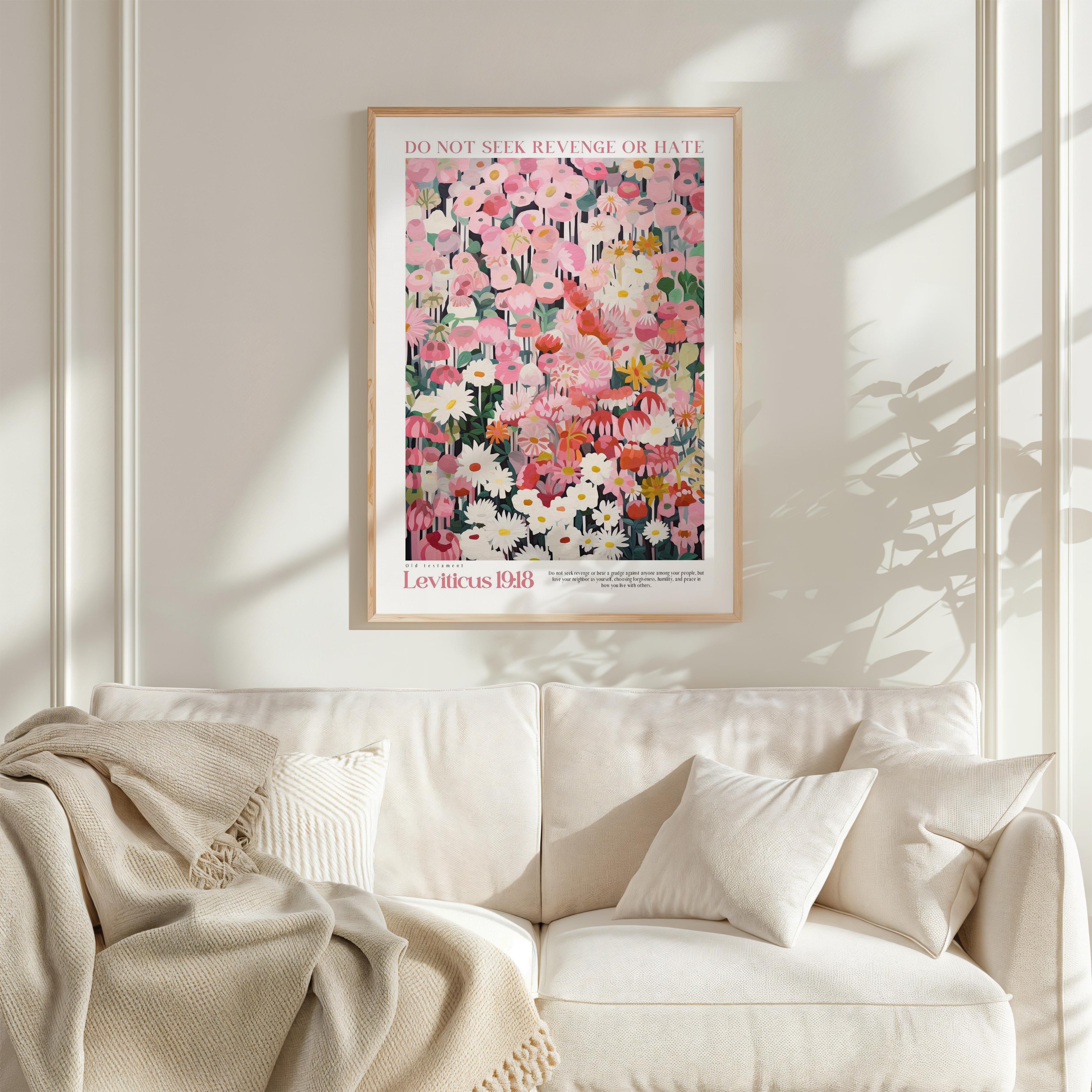 a framed poster of a colorful floral painting hanging on a wall above a white couch with pillows.