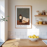 a kitchen scene with a framed poster of a lantern, a bowl of lemons, and a shelf with jars of food.