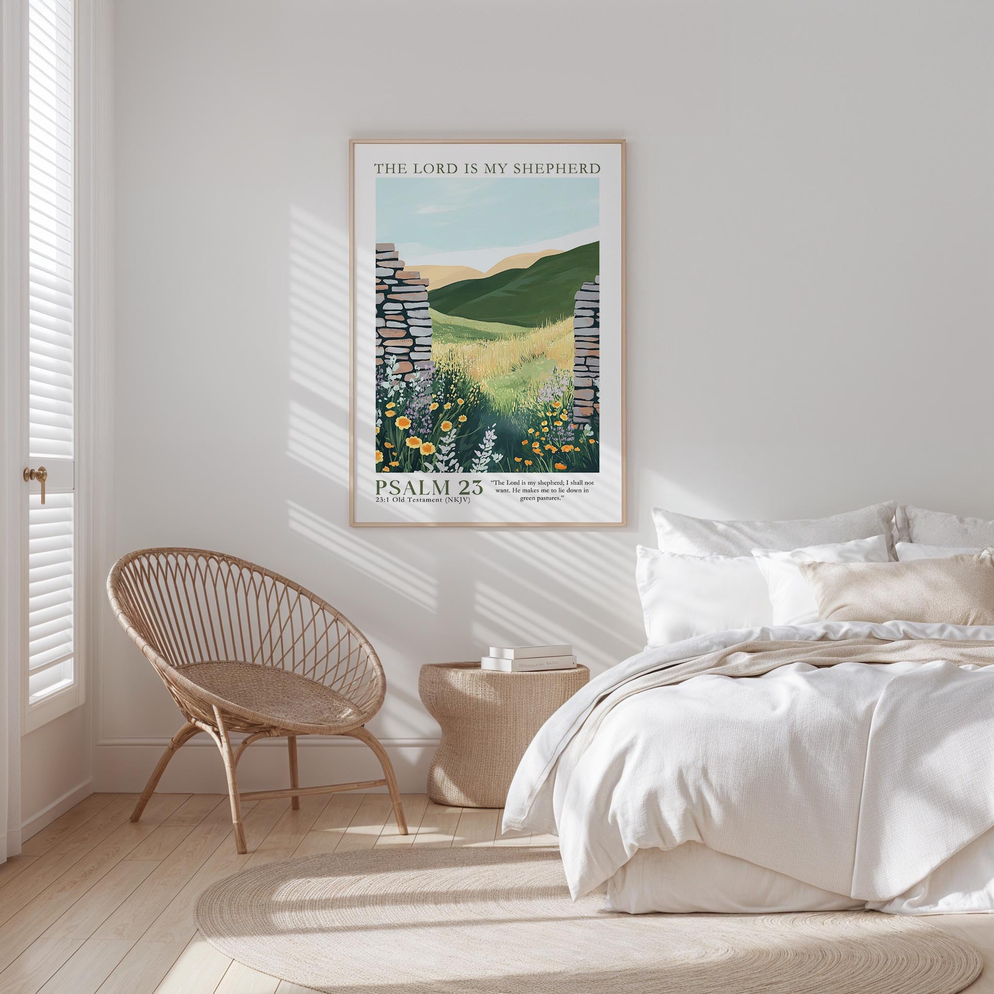 A bedroom with a bed, a woven chair, and a framed poster of a pastoral landscape hanging on the wall.