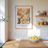 a kitchen scene with a framed poster of a floral design on the wall above a wooden countertop with a bowl of lemons.