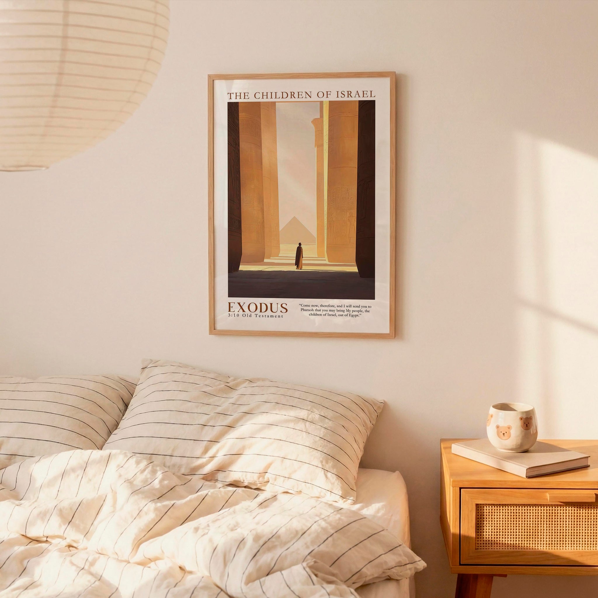 a bedroom scene with a framed poster of a building and a bed with striped bedding.