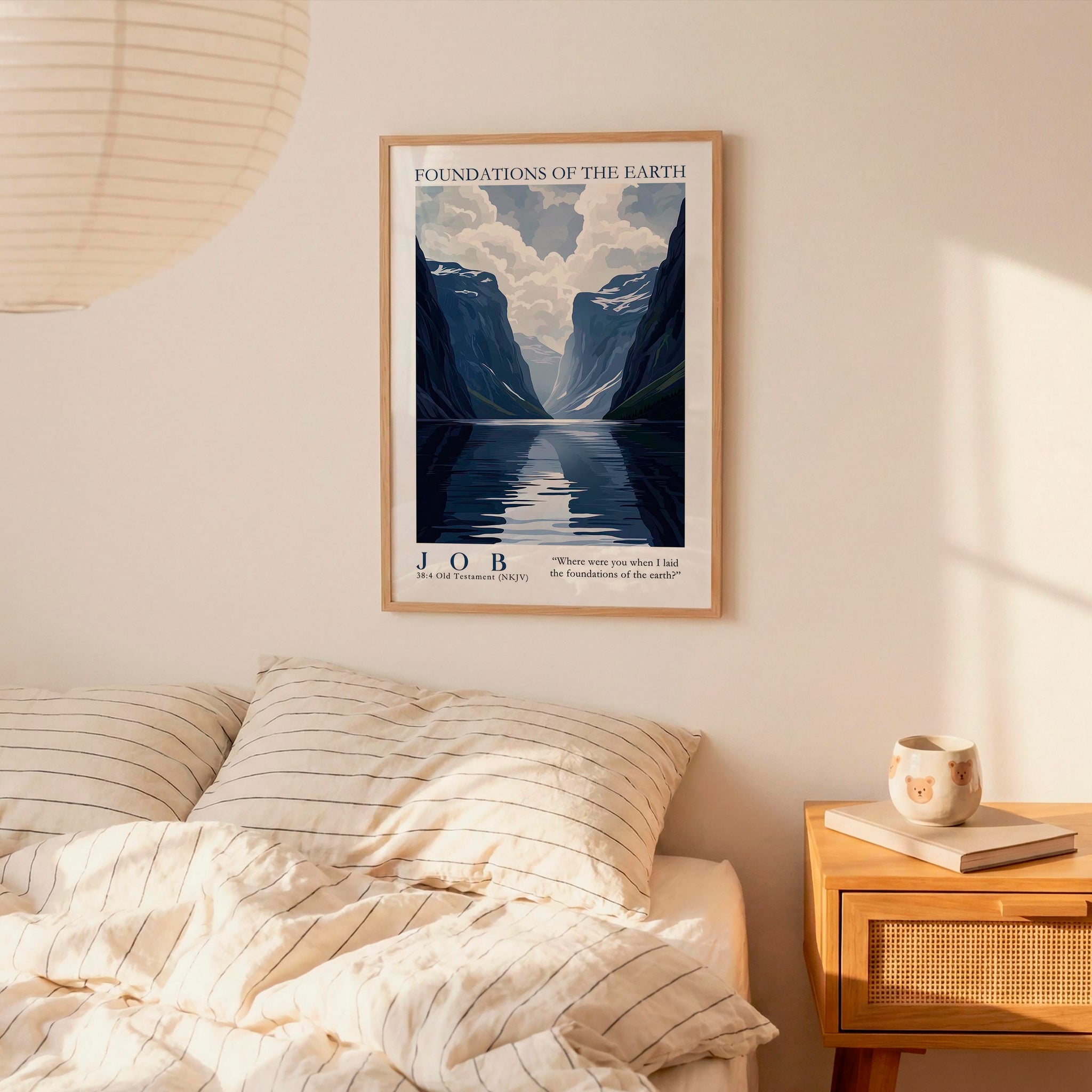 a bedroom setting with a framed poster of a mountain landscape hanging on the wall above a bed with striped bedding.