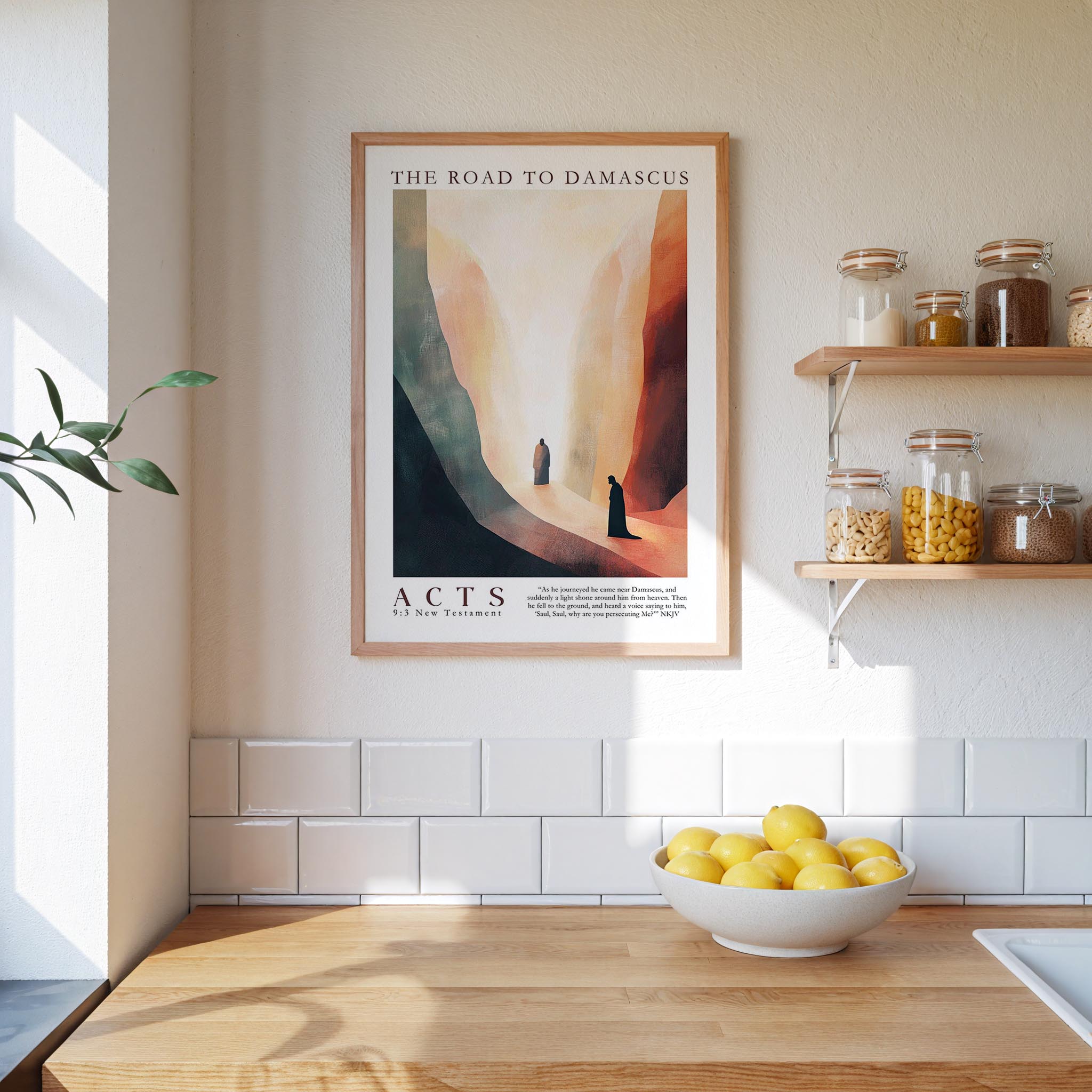 a kitchen counter with a bowl of lemons, a framed poster of a desert landscape, and a shelf with jars and containers.