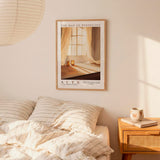 a bedroom scene with a framed poster of a window and curtains hanging on the wall above a bed with striped bedding.