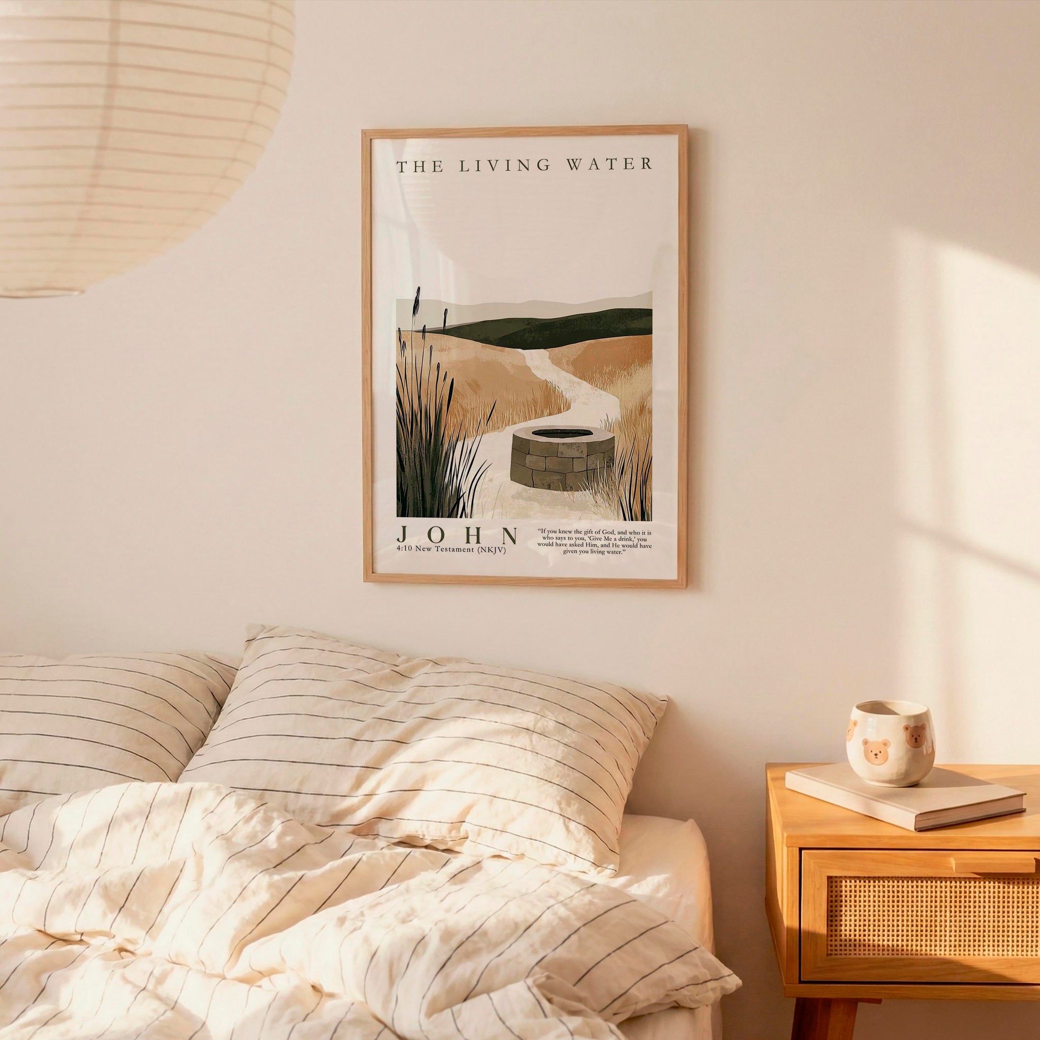 a bedroom scene with a framed poster of a well and a bed with striped pillows.
